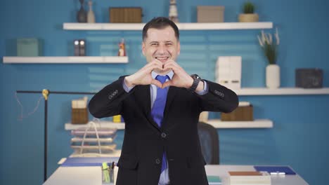 Businessman-making-heart-with-hands-looking-at-camera.